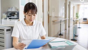 地域包括ケア病棟で退院支援の資料を確認する看護師