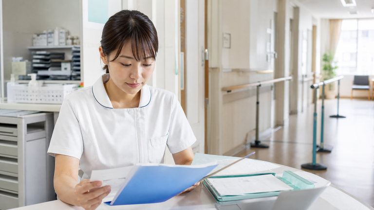 地域包括ケア病棟で退院支援の資料を確認する看護師