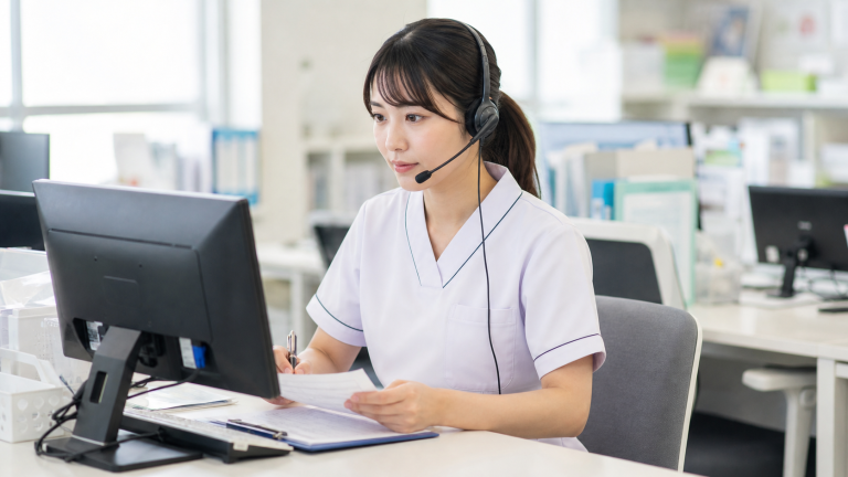 医療相談のコールセンターでヘッドセットを付けて対応する看護師