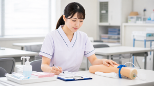 採血練習のために研修室で手順を確認する看護師