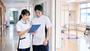 回復期リハビリ病棟で看護師とリハビリ職が患者支援を確認している様子