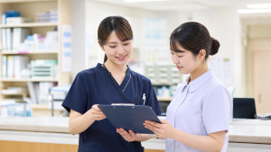 看護助手配置がある職場で看護師と助手が業務分担を確認している様子