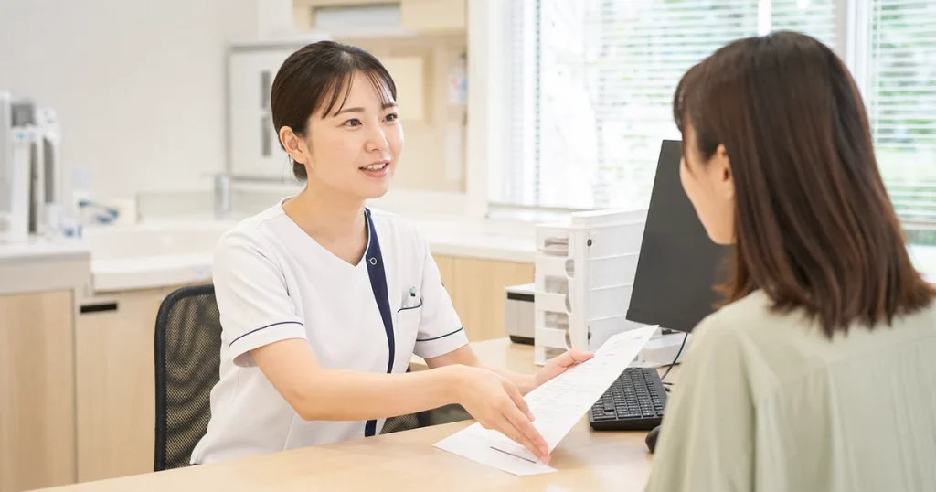 甲状腺クリニックで患者に資料を見せながら説明する看護師