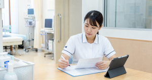 手術前外来の看護師求人を確認するために術前書類を確認する看護師