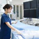 心臓カテーテル室で検査準備とモニターを確認する看護師