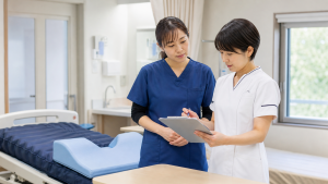 褥瘡対策チームで体圧分散マットレスとケア計画を確認する看護師